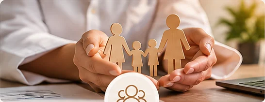 Mãos protegendo uma família de papel